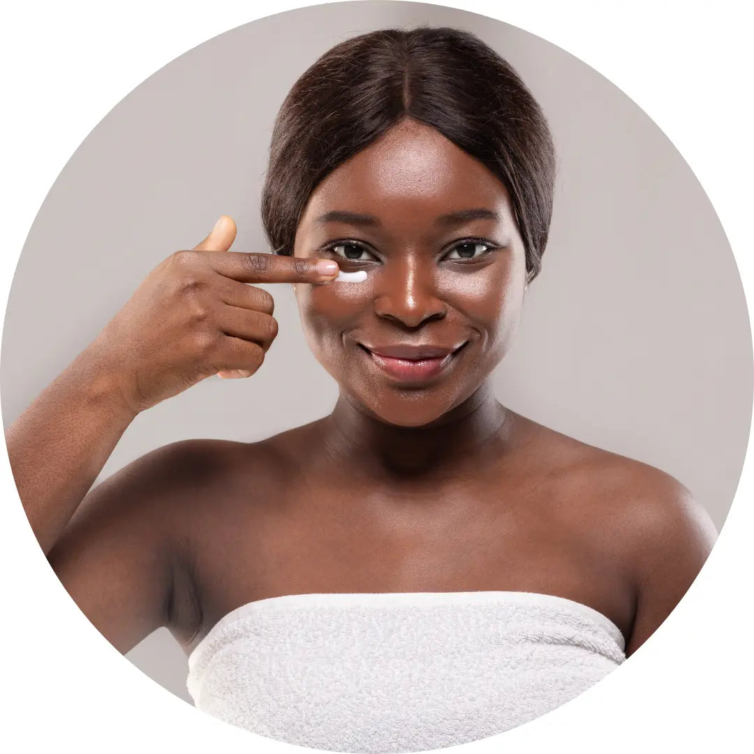 Beautiful black woman applying Buddha Beauty eye cream 