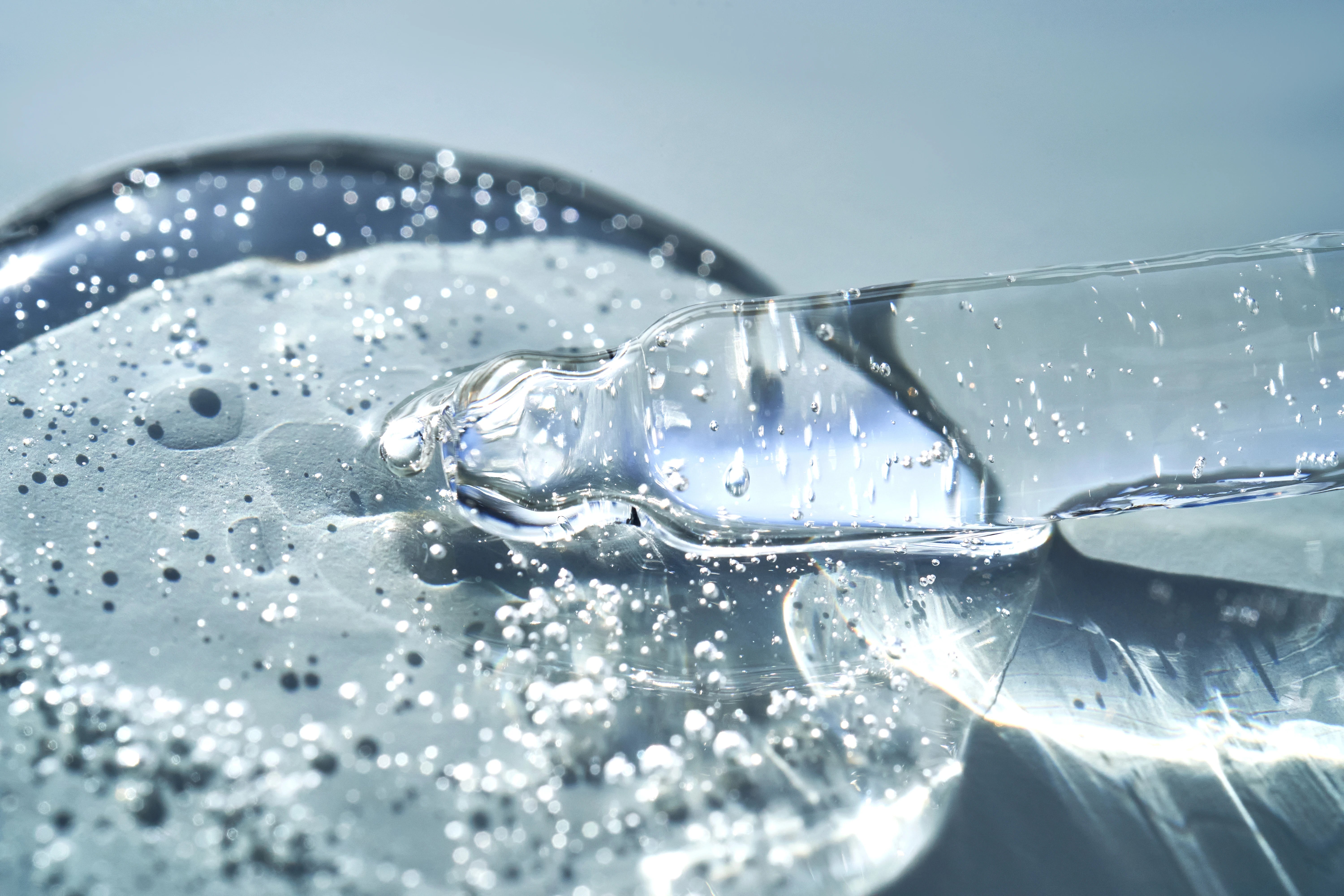 pipette-with-hyluonic acid-serum-shimmering-in-the-sun-on-a-blue-background_45860984