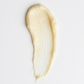 Close-up of a smooth, beige cream swatch on a light gray background