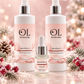 Three OL Skincare products arranged together on a reflective surface: two large pump bottles labeled Spiced Berry Hand & Body Wash and one smaller dropper bottle labeled cuticle Oil, set against a soft pink holiday-themed background with pine branches and red berries.