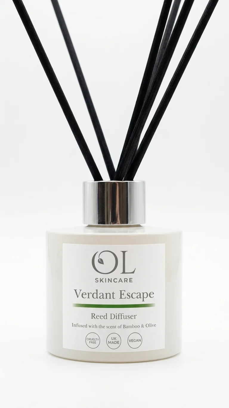 OL Skincare Verdant Escape Reed Diffuser with a white cylindrical bottle, a silver metallic collar, and multiple black reed sticks, shown on a clean white background.