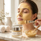 Woman applying turmeric clay mask with brush