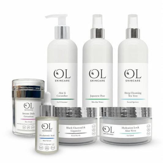 A collection of OL Skincare products arranged on a white background, including pump bottles, jars, and a dropper bottle with white labels and silver caps.