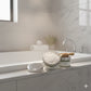 Japanese pear hair scrub  on a bathroom counter with a bathtub and mirror in the background